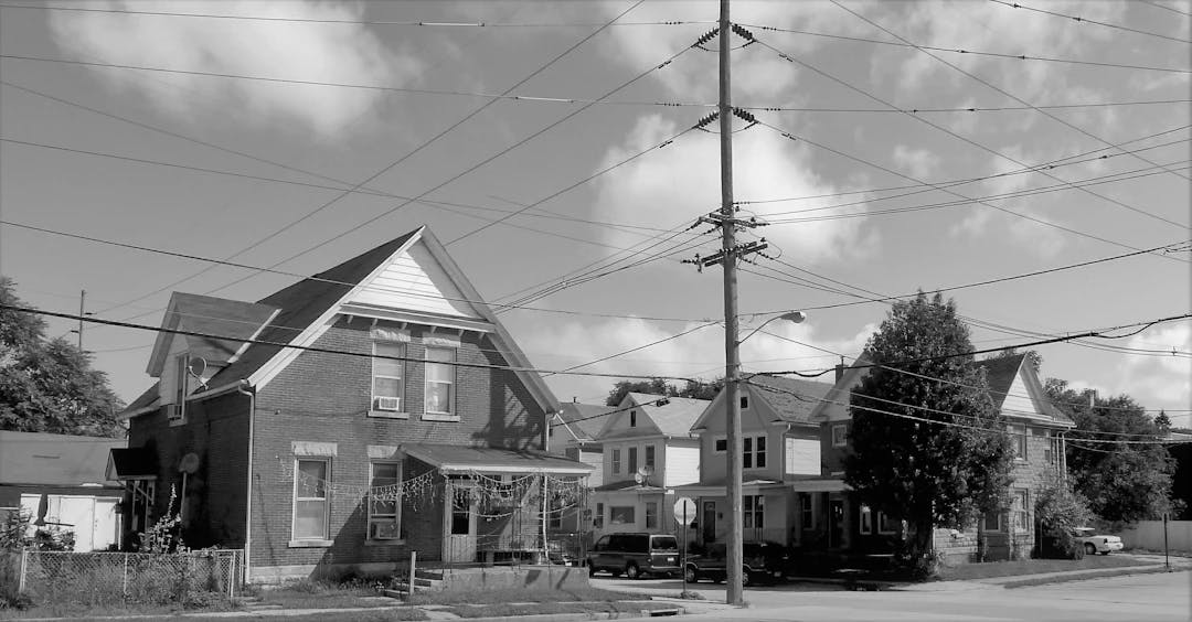 a black and white photo of houses and power lines