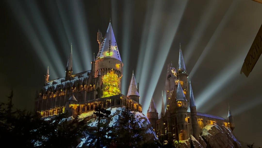 a castle lit up at night with beams of light