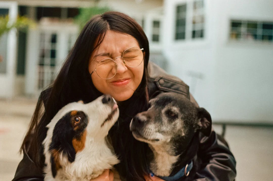 a woman holding two dogs in her arms